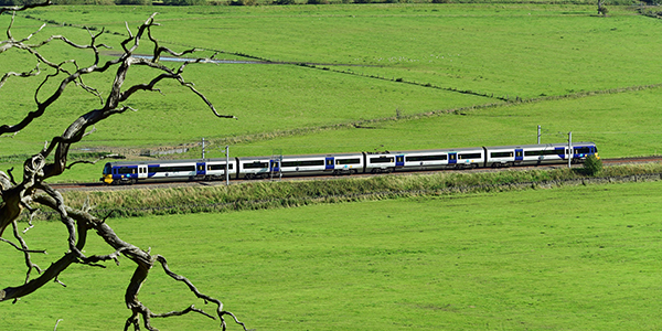 train-travelling-through-green-fields-600x300