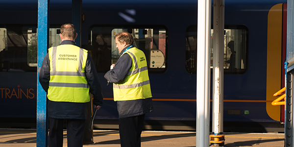 Members of staff on station platform in yellow jackets