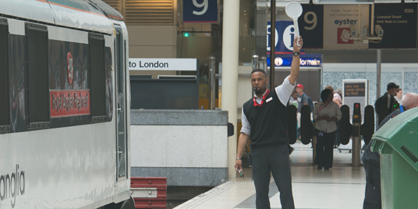 Train dispatch guard signalling safe departure to train driver