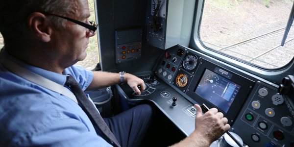 Train driver in cab driving train