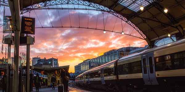 promo-image-june-2023-train-station-platfrom-passengers-sunset-scenery