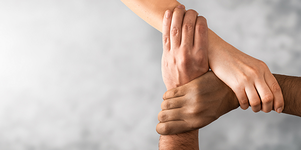 support-three-people-holding-wrists-promo